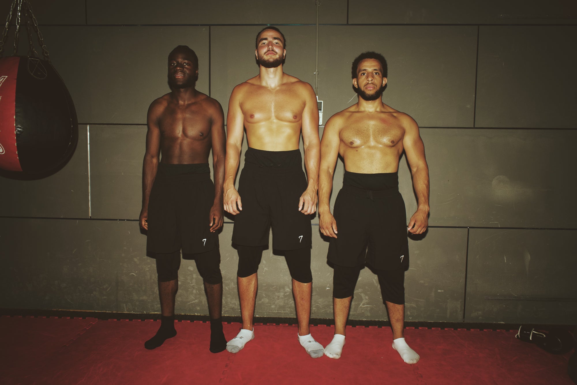 Three athletes of different builds standing together, each wearing the 7ayaa Performance Shorts over the legging layer